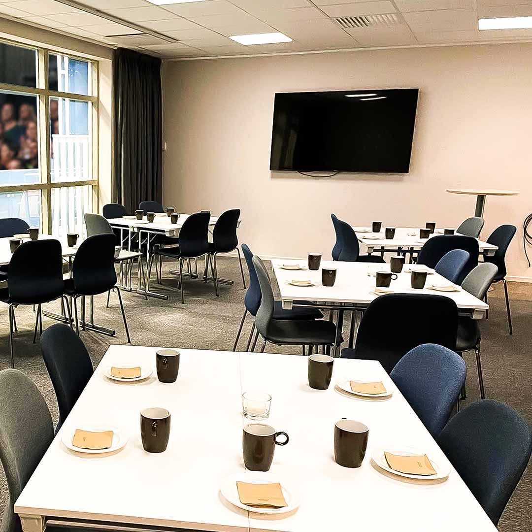Konferensrum med fikadukade bord och skärm